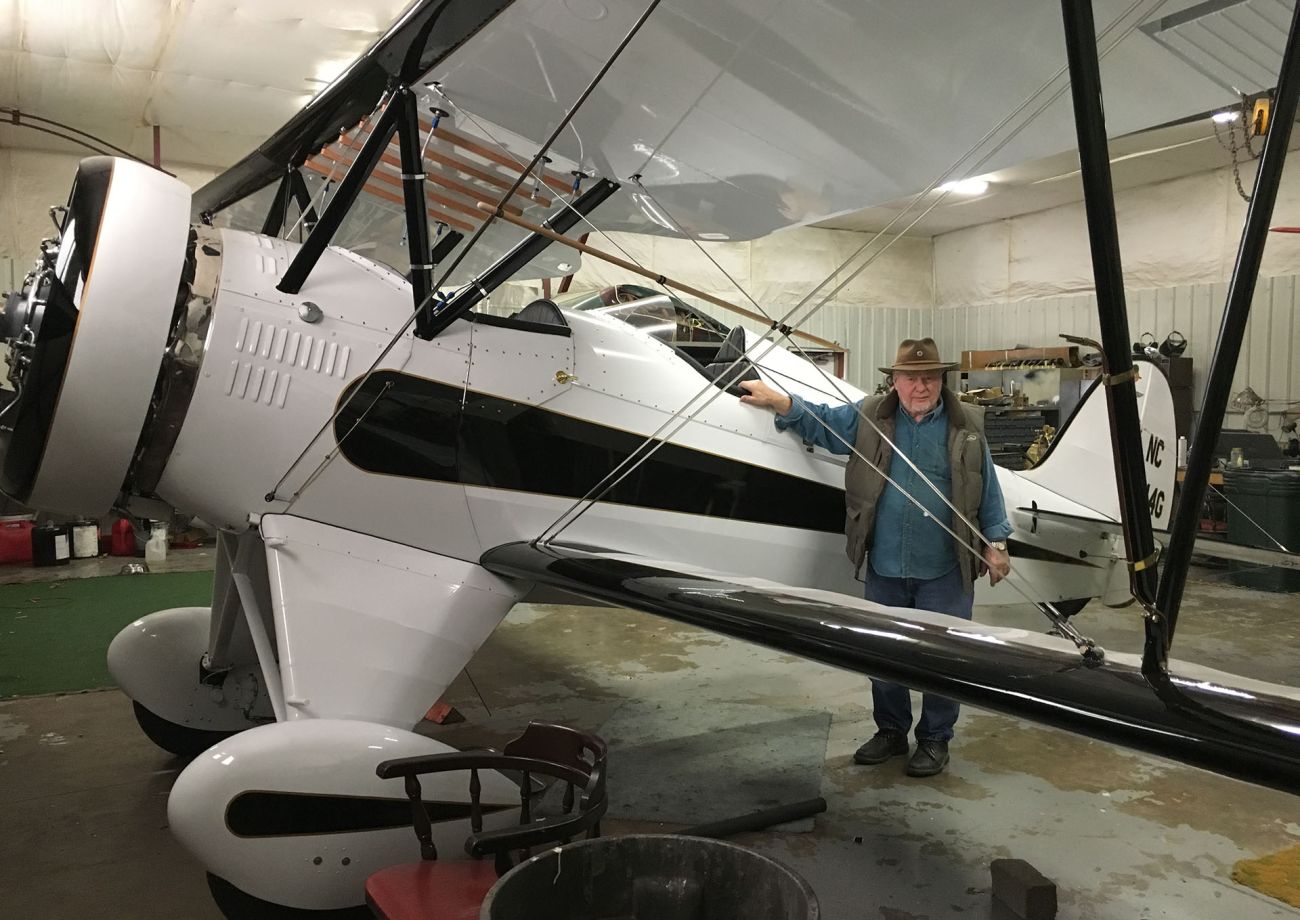 john cournoyer standing in front of a newly renovated waco biplane