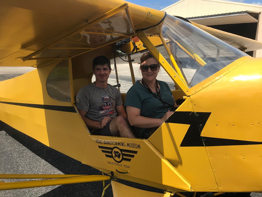 woman and young man sitting in cockpit of the piper cub