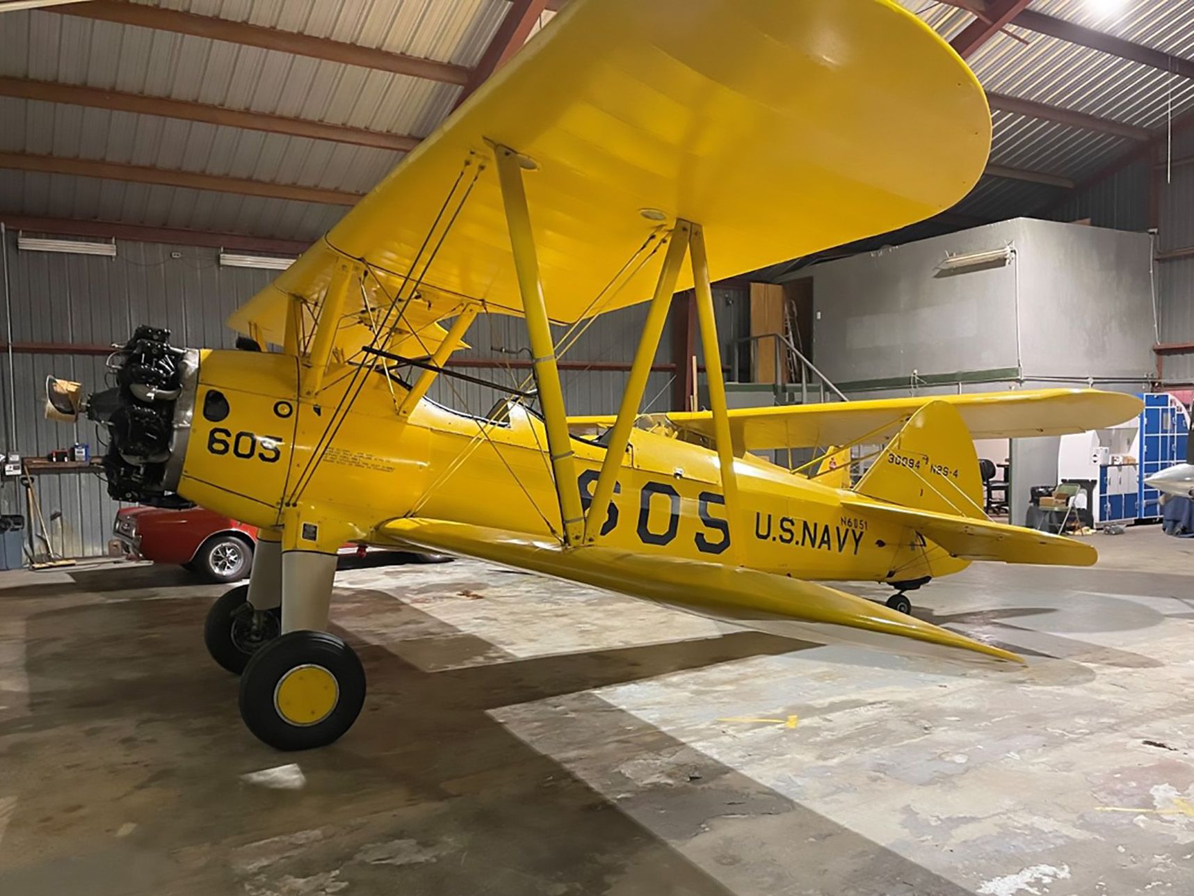 yellow stearman sitting in a hangar